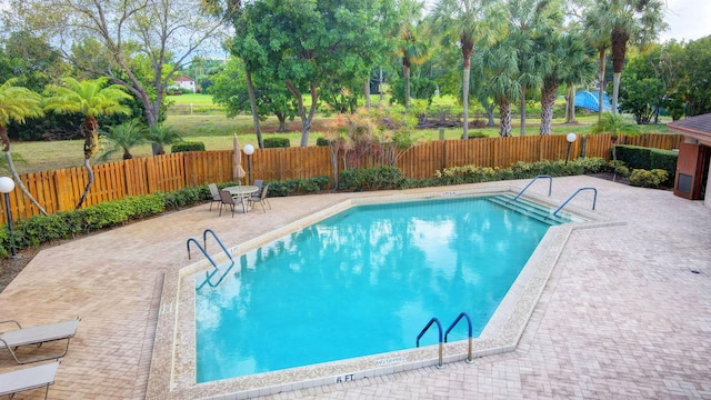 pool featuring fence and a patio