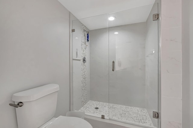 bathroom with a shower stall and toilet