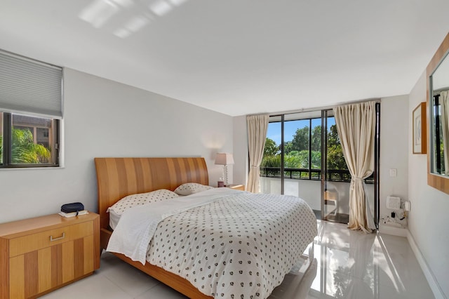 bedroom with expansive windows and baseboards