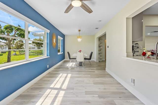 dining space with light wood-type flooring, visible vents, ceiling fan, and baseboards