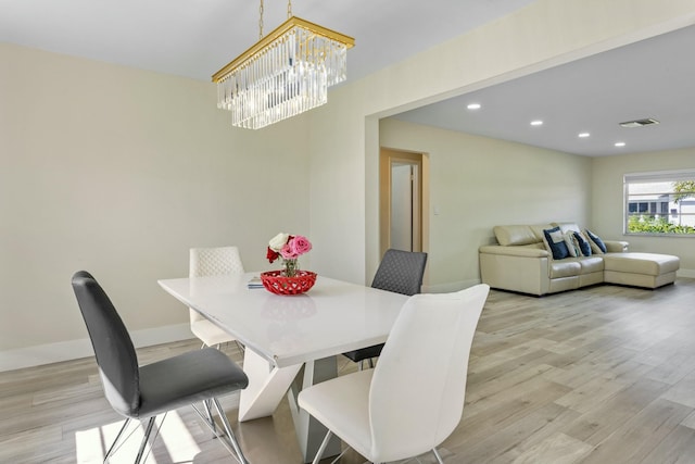 dining area with recessed lighting, visible vents, light wood-style flooring, an inviting chandelier, and baseboards