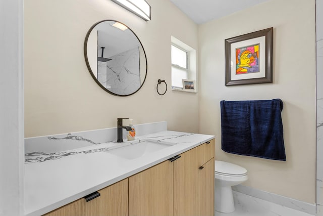 bathroom with toilet, marble finish floor, and vanity