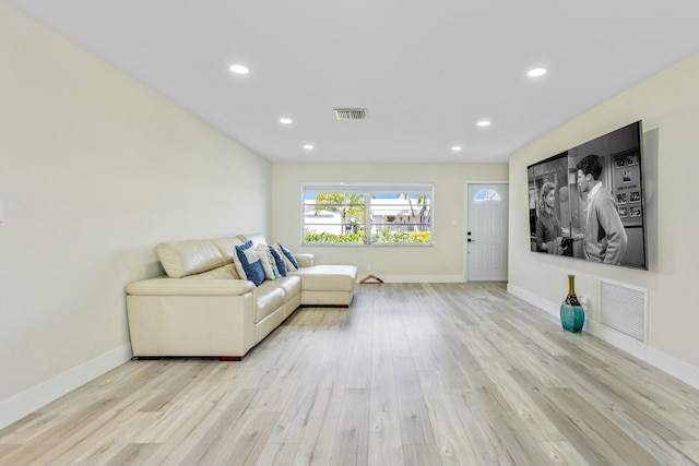 living area featuring baseboards, light wood-type flooring, visible vents, and recessed lighting