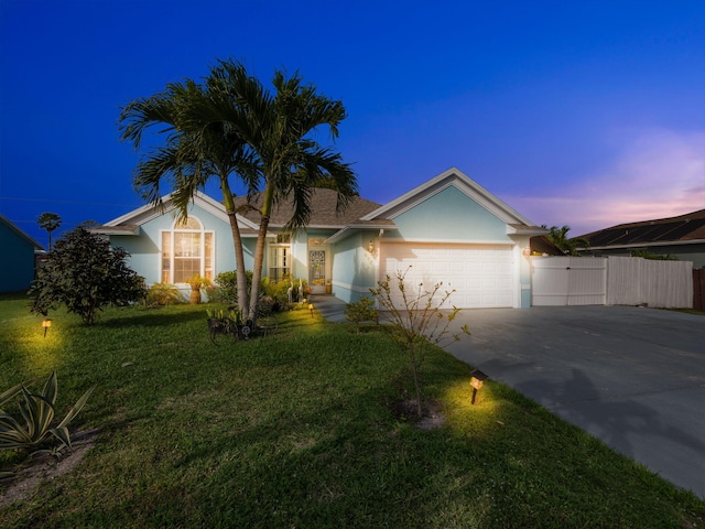 single story home featuring stucco siding, concrete driveway, a lawn, fence, and a garage