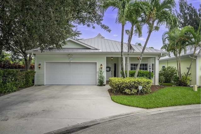 ranch-style home featuring a garage, a standing seam roof, metal roof, and concrete driveway