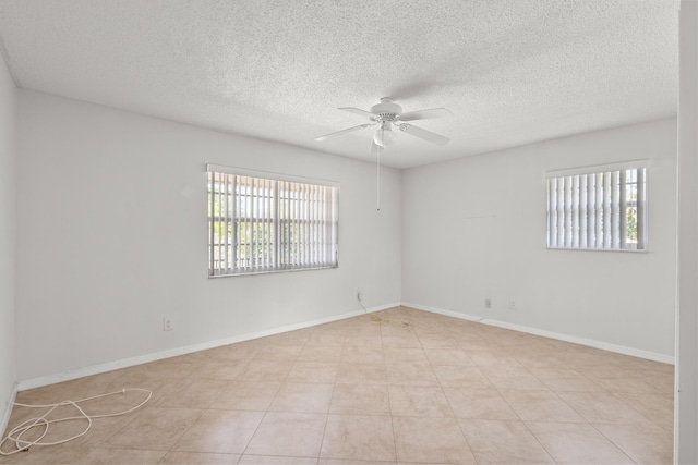 unfurnished room with a wealth of natural light, baseboards, and ceiling fan