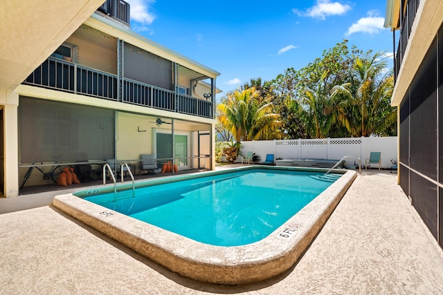 pool with a patio, a fenced backyard, and a sunroom