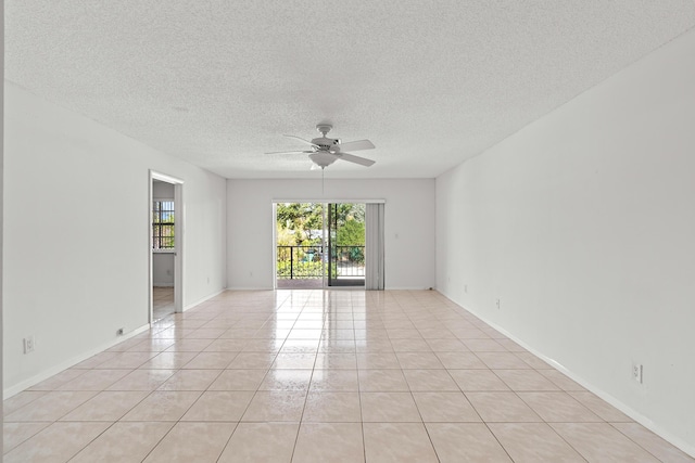 empty room featuring light tile patterned floors, baseboards, a textured ceiling, and ceiling fan