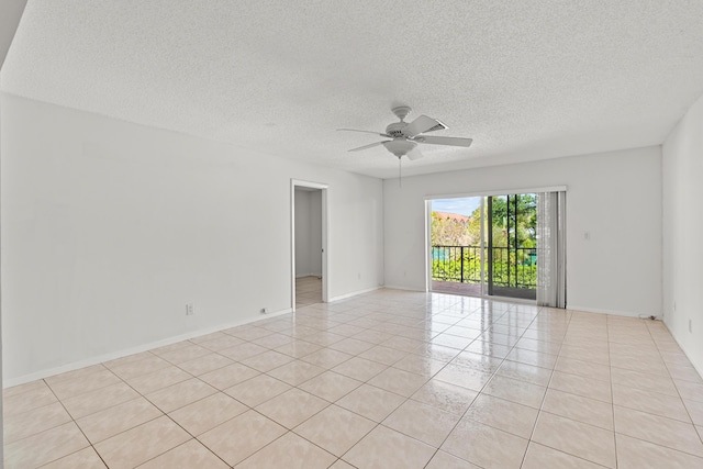 empty room with light tile patterned floors, baseboards, a textured ceiling, and a ceiling fan