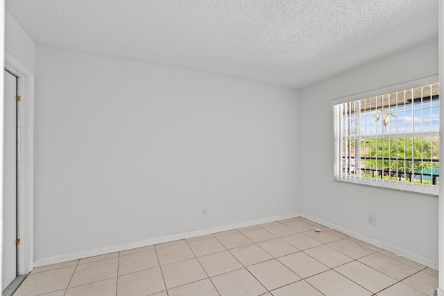 spare room featuring baseboards and a textured ceiling