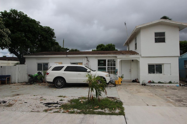 view of front of home featuring brick siding and fence