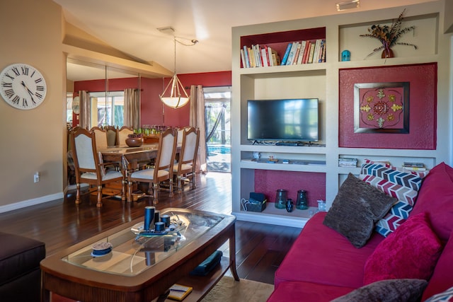 living room with lofted ceiling, built in shelves, baseboards, and dark wood-style flooring