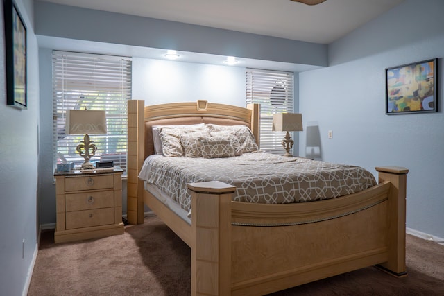 bedroom with dark colored carpet and baseboards