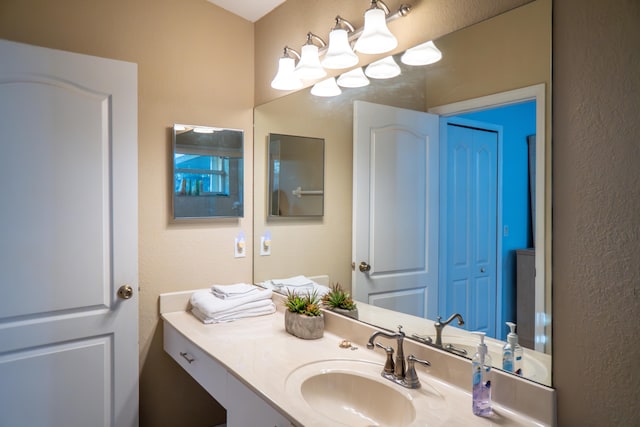bathroom featuring a textured wall and vanity