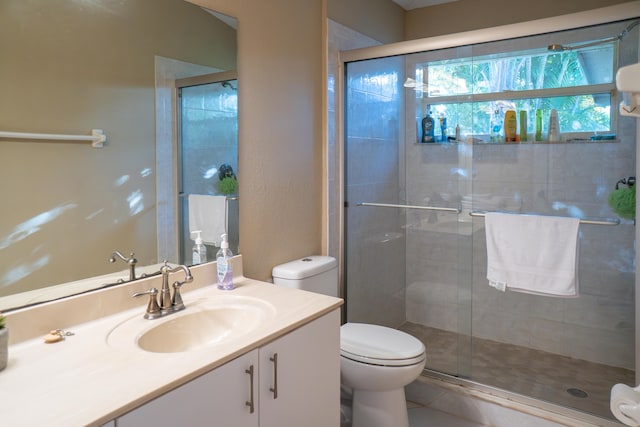 bathroom with tile patterned flooring, a shower stall, vanity, and toilet