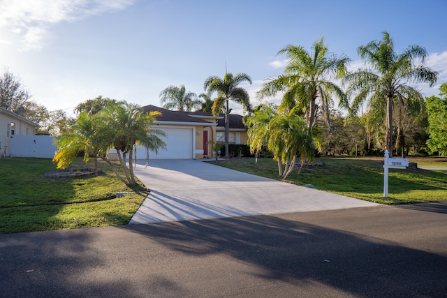 view of front of house featuring a garage, driveway, and a front yard