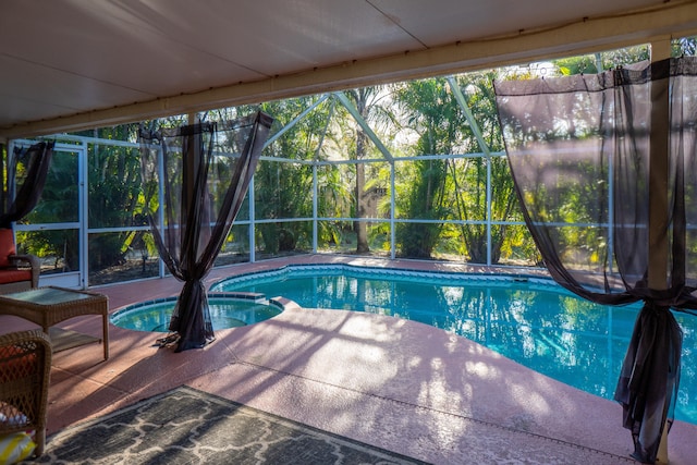 view of swimming pool featuring a lanai, a pool with connected hot tub, and a patio