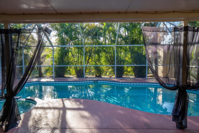view of swimming pool with a lanai and a pool with connected hot tub