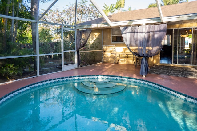 outdoor pool with a patio area and glass enclosure