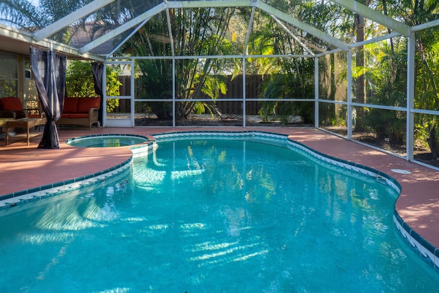 view of pool featuring a lanai, a patio area, a fenced backyard, and a pool with connected hot tub