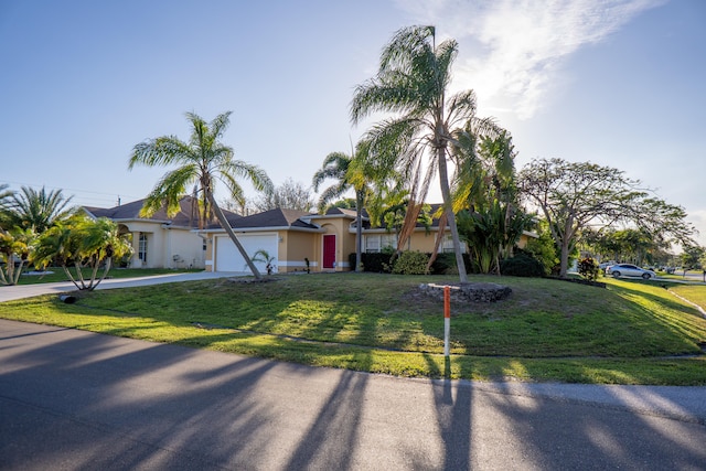 view of front of property with a front lawn, driveway, an attached garage, and stucco siding