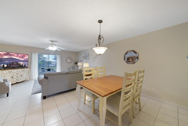 dining room featuring a textured ceiling, ceiling fan, light tile patterned floors, and baseboards