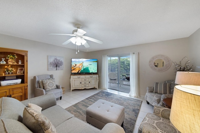 living area featuring light tile patterned floors, a ceiling fan, and a textured ceiling