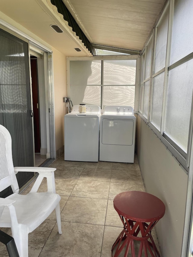 138 Monaco C, Delray Beach, FL 33446 - laundry area featuring washer and dryer, a sunroom, and light tile patterned floors