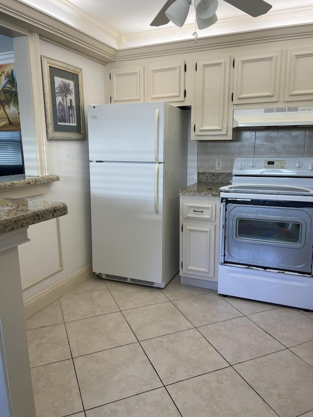 138 Monaco C, Delray Beach, FL 33446 - kitchen with crown molding, range with electric stovetop, light tile patterned floors, freestanding refrigerator, and under cabinet range hood