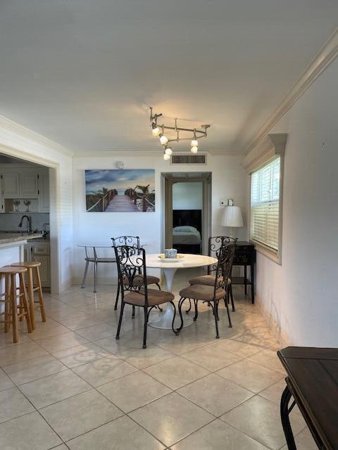 138 Monaco C, Delray Beach, FL 33446 - dining area featuring light tile patterned floors, visible vents, and ornamental molding