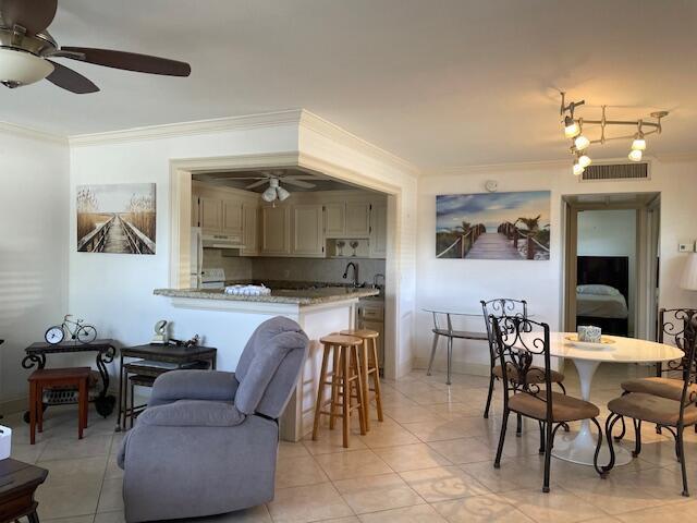 138 Monaco C, Delray Beach, FL 33446 - dining space with ceiling fan, light tile patterned flooring, visible vents, and crown molding