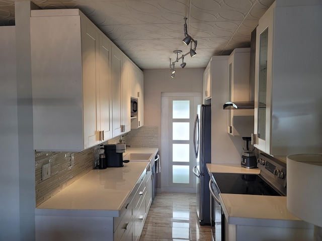 kitchen with electric range, white cabinets, light countertops, and freestanding refrigerator