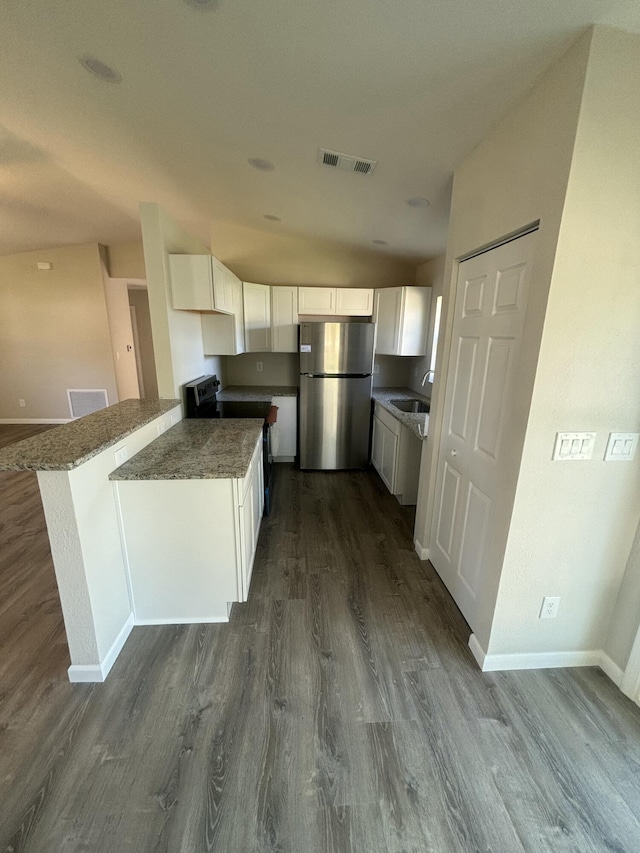 kitchen featuring a peninsula, a sink, visible vents, white cabinets, and appliances with stainless steel finishes