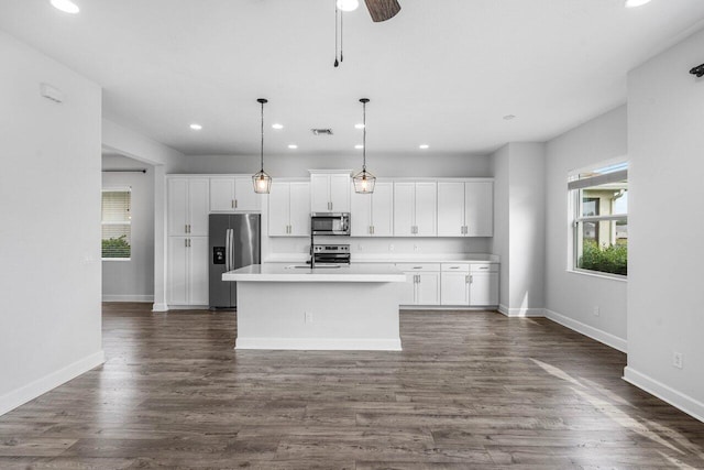 15262 Goldfinch Cir, Westlake, FL 33470 - kitchen featuring stainless steel appliances, recessed lighting, white cabinets, a center island with sink, and baseboards