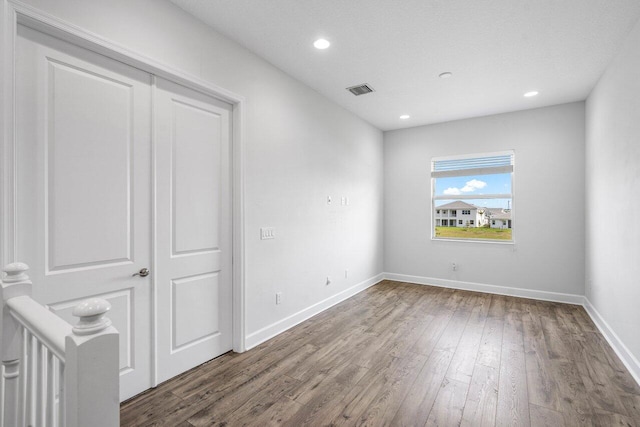 unfurnished bedroom featuring visible vents, baseboards, wood finished floors, and recessed lighting