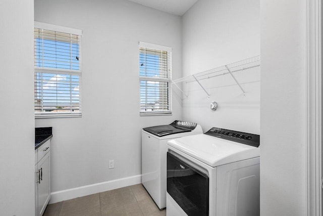 laundry area with laundry area, light tile patterned flooring, baseboards, and washing machine and clothes dryer