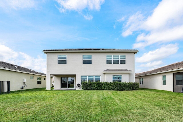 rear view of property with a lawn and stucco siding