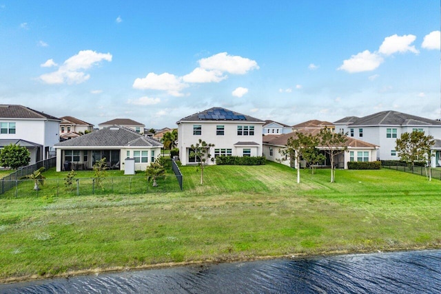 15262 Goldfinch Cir, Westlake, FL 33470 - rear view of property with a residential view, a fenced backyard, roof mounted solar panels, and a water view