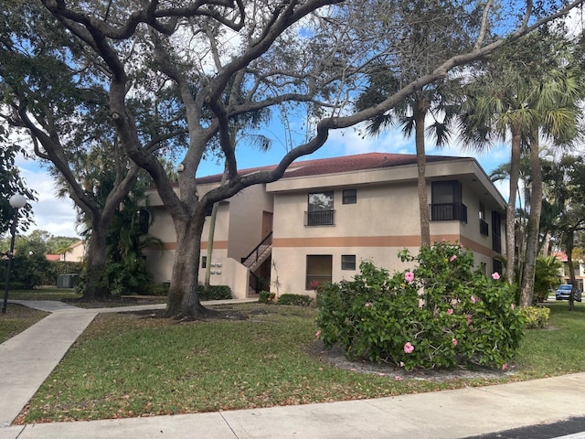 view of front of property featuring a front lawn and stucco siding