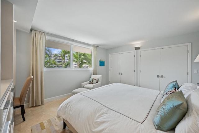 bedroom featuring two closets and baseboards