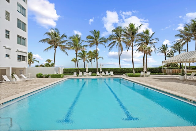 pool with a patio and fence