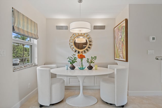 dining space featuring breakfast area and baseboards