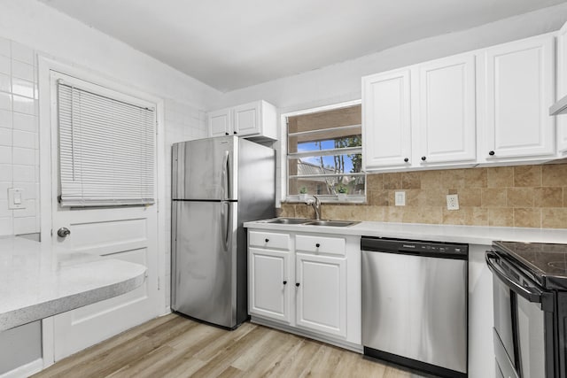 10821 N Military Trl Unit 2, Palm Beach Gardens, FL 33410 - kitchen with stainless steel appliances, a sink, white cabinetry, light wood-style floors, and light countertops