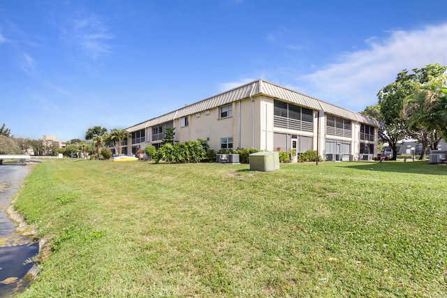 10821 N Military Trl Unit 2, Palm Beach Gardens, FL 33410 - view of side of home featuring stucco siding, a lawn, and central AC