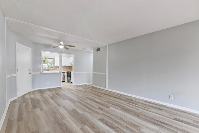 10821 N Military Trl Unit 2, Palm Beach Gardens, FL 33410 - unfurnished living room featuring light wood-style flooring, a ceiling fan, and baseboards