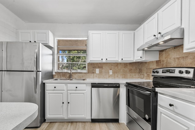 10821 N Military Trl Unit 2, Palm Beach Gardens, FL 33410 - kitchen featuring stainless steel appliances, under cabinet range hood, a sink, light countertops, and white cabinets