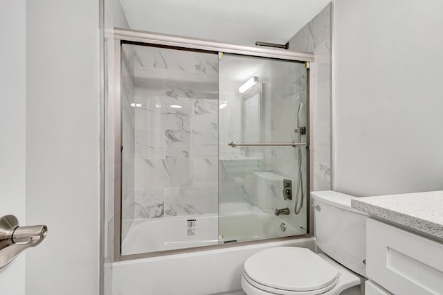 bathroom with vanity, toilet, and bath / shower combo with glass door