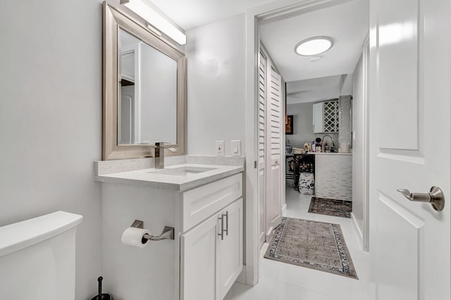 bathroom with a closet, vanity, and toilet