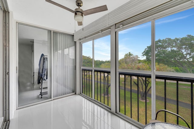 unfurnished sunroom featuring ceiling fan