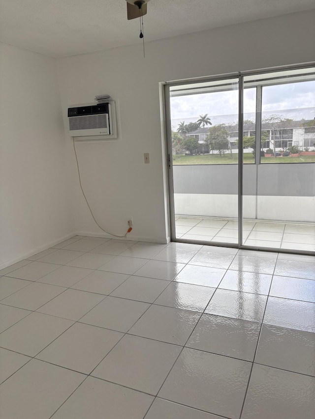 spare room with a wall unit AC and light tile patterned floors